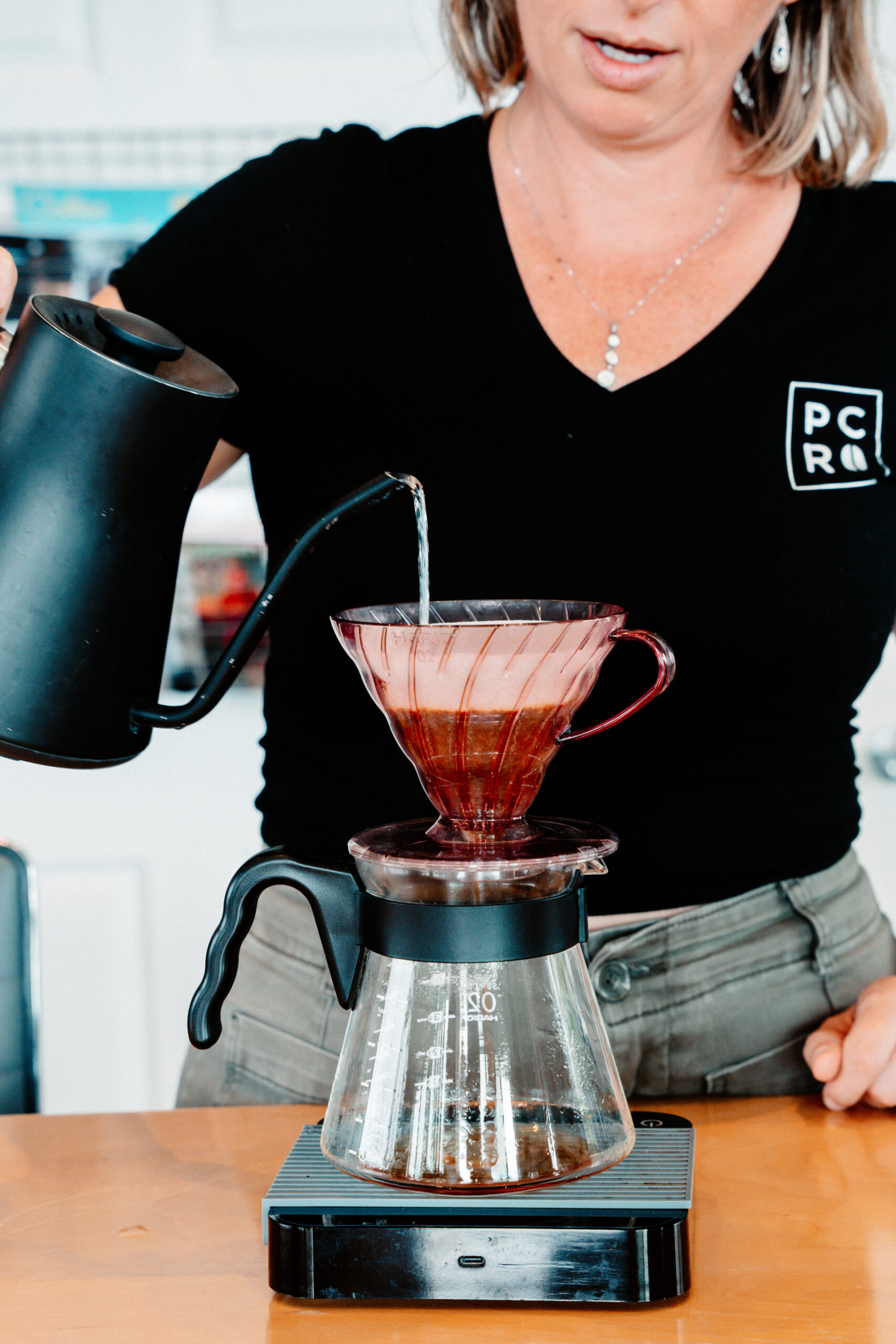 Pacific Coffee Research team member brewing pour-over coffee